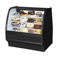 Curved glass bakery display case filled with an assortment of cakes and pastries, designed for optimal visibility.