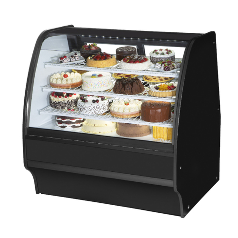Curved glass bakery merchandiser showcasing a variety of cakes and pastries in an elegant display.